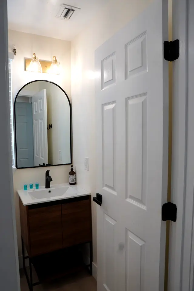 Bathroom vanity at villa 5012 with an arched mirror