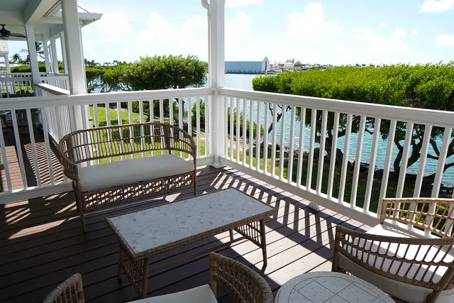 The view from the porch at villa 5012: lawn, shade trees and open water