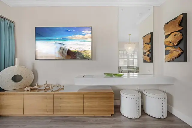 Console table and television at villa 5092, with coastal artwork